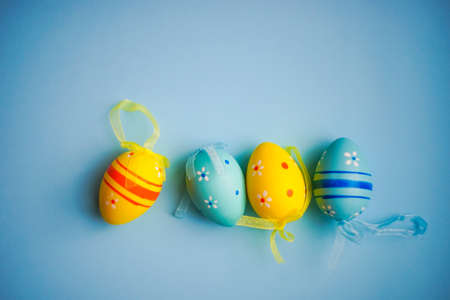 Easter holiday card with colored eggs on pastel blue backgroundの写真素材