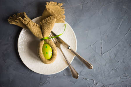 Festive easter table setting with colored eggs and easter bunny concept with copyspaceの写真素材