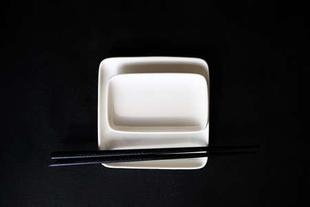 Minimalistic rustic table setting with chopsticks on blacktableの写真素材
