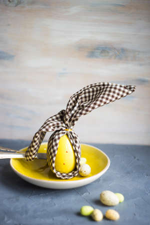 Festive easter table setting with colored eggs and easter bunny concept with copyspaceの写真素材