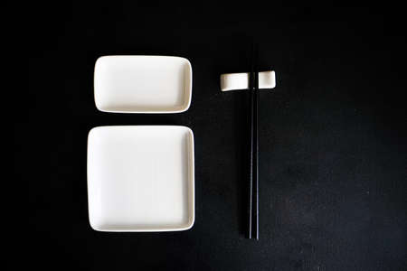Minimalistic rustic table setting with chopsticks on blacktableの写真素材