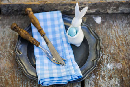 Easter holiday card with table setting with colored eggs on pastel backgroundの写真素材