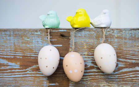 Easter holiday card with easter eggs and birds on rustic wooden background with copy spaceの写真素材