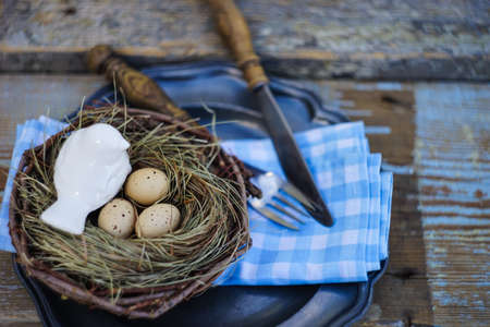 Easter holiday card with table setting with colored eggs on pastel background