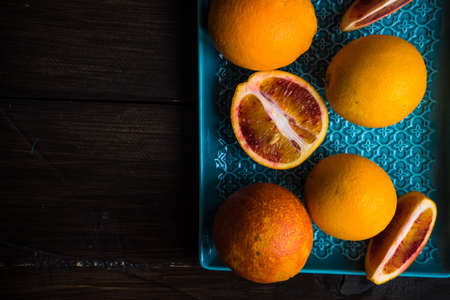 Slices of organic red orange fruit on beautiful ceramic plate with copy space