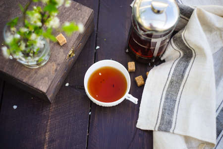 Tea pot, cup of tea, blooming cherry and spices on rustic wooden tableの写真素材