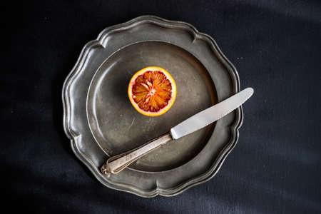 Slices of organic red orange fruit on beautiful ceramic plate with copy spaceの写真素材