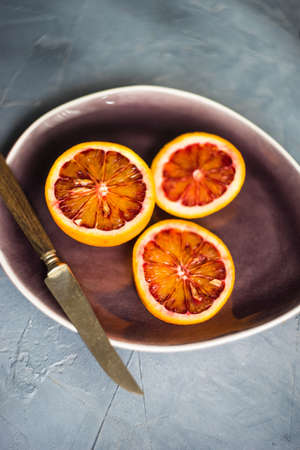 Slices of organic red orange fruit on beautiful ceramic plate with copy spaceの写真素材