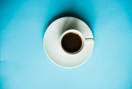 Coffee concept with cup of coffee on blue background with copy space