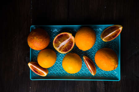 Slices of organic red orange fruit on beautiful ceramic plate with copy space
