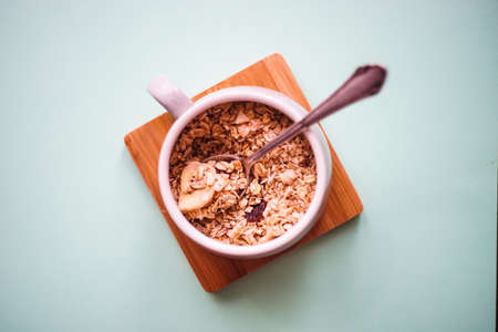 Healthy breakfast with oatmeals with organic fruits on green background with copy spaceの写真素材