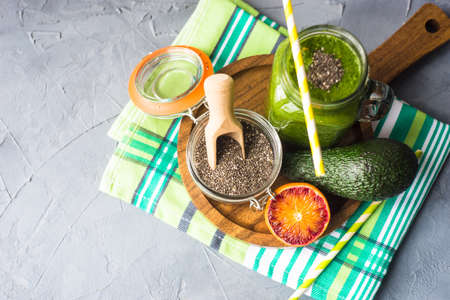 Organic and healthy green smoothie with banana, spinach, avocado, citrus fruits and chia seeds in a glass bottles on a rustic background withcopy spaceの写真素材