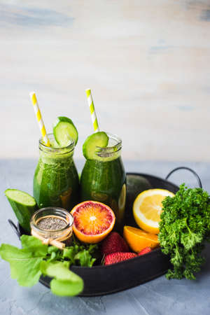 Organic and healthy green smoothie with banana, spinach, avocado, citrus fruits and chia seeds in a glass bottles on a rustic background withcopy spaceの写真素材