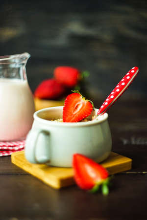 Healthy breakfast with oatmeals with organic strawberries on rustic background with copy spaceの写真素材