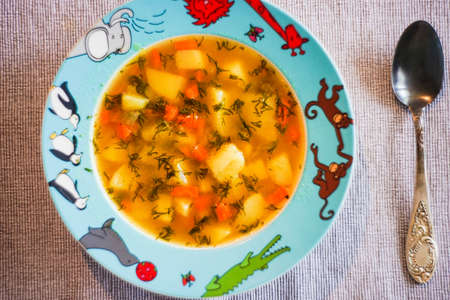 Healthy vegetable soup for kid's dinner on a tableの写真素材