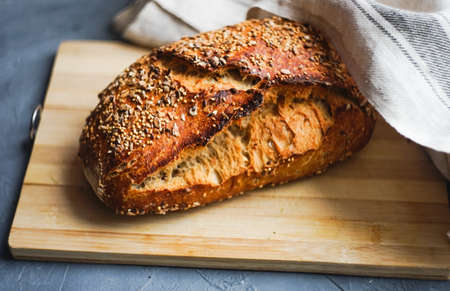 Fresh baked homemade bread with seeds on cutting board