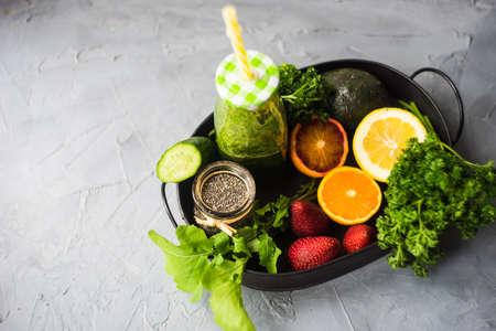 Organic and healthy green smoothie with banana, spinach, avocado, citrus fruits and chia seeds in a glass bottles on a rustic background withcopy spaceの写真素材