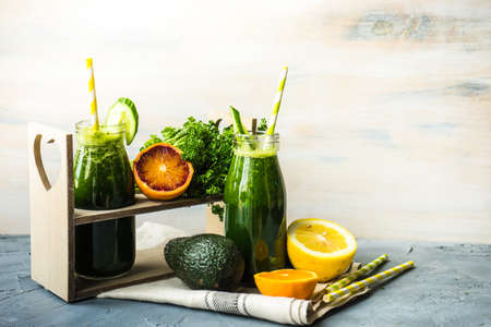 Organic and healthy green smoothie with banana, spinach, avocado, citrus fruits and chia seeds in a glass bottles on a rustic background withcopy spaceの写真素材