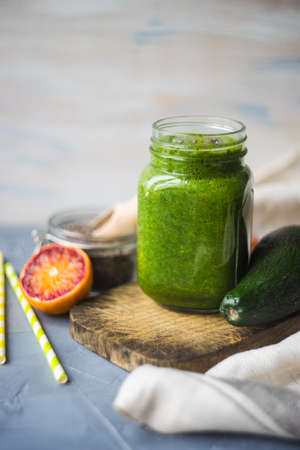 Organic and healthy green smoothie with banana, spinach, avocado, citrus fruits and chia seeds in a glass bottles on a rustic background withcopy spaceの写真素材