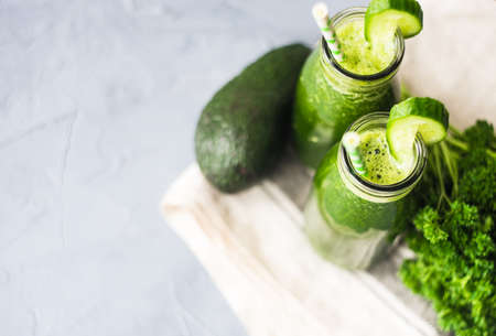 Organic and healthy green smoothie with banana, spinach, avocado, citrus fruits and chia seeds in a glass bottles on a rustic background withcopy spaceの写真素材