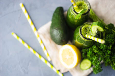 Organic and healthy green smoothie with banana, spinach, avocado, citrus fruits and chia seeds in a glass bottles on a rustic background withcopy spaceの写真素材