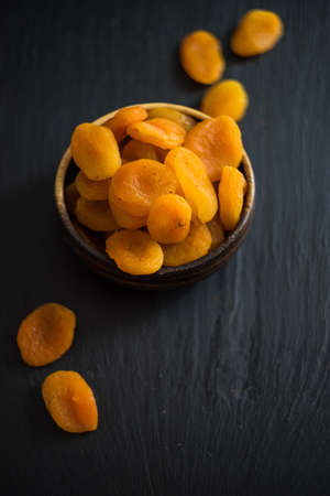 Organic dried apricot in a rustic bowl with copy spaceの写真素材