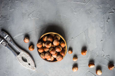 Organic nuts in a wooden bowl on grey concrete background in food concept