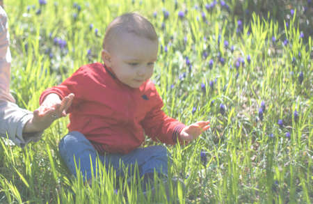 Mom and little baby boy playing outdoor together in a spring time parkの写真素材