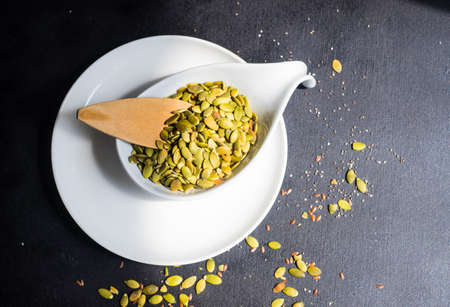 Raw pumpkin seeds as a organic and superfood concept on rustic background with copy space