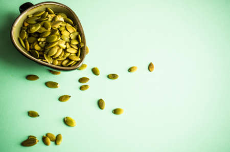 Raw pumpkin seeds as a organic and superfood concept on green background with copy spaceの写真素材