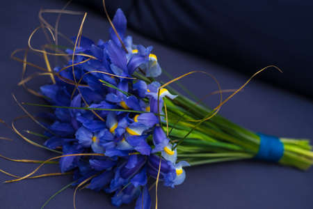 Beautiful blue mini irises in a bouquet on rustic background with copy spaceの写真素材