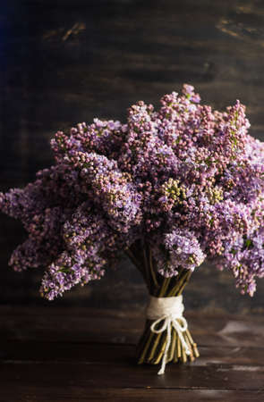 Beautiful purple lilac flowers in a bunch on rustic background with copy space