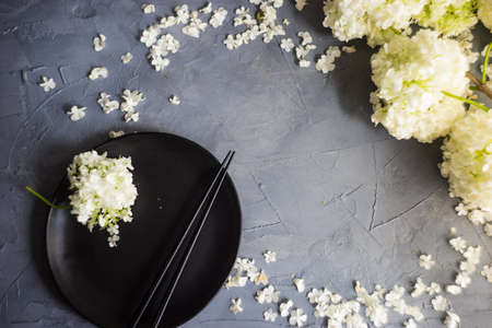 Summer table setting with white  Viburnum opulus 'Roseum' flowers on rustic background