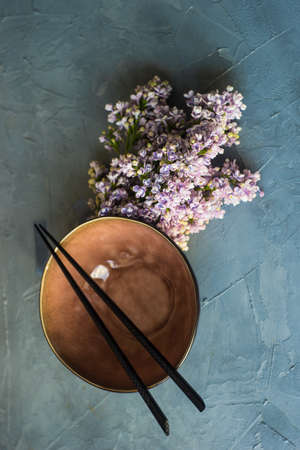Spring table setting for asian food dinner with lilac flowers on rustic table with copy spaceの写真素材