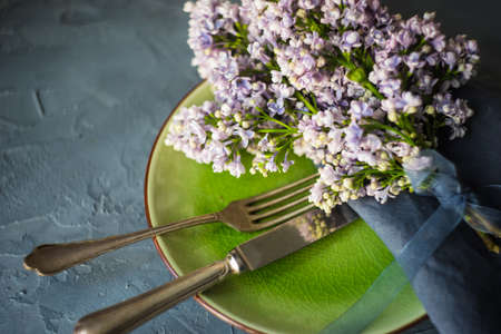 Spring table setting  with lilac flowers on rustic table with copy spaceの写真素材