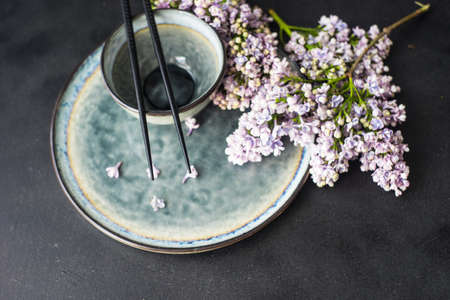 Spring table setting for asian food dinner with lilac flowers on rustic table with copy space