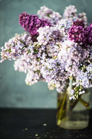 Spring lilac bunch in a vase on rustic table with copy space