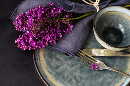Spring table setting  with lilac flowers on rustic table with copy space
