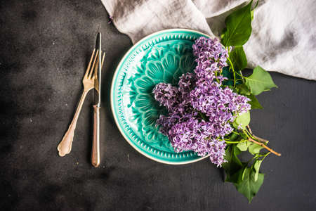 Spring table setting  with lilac flowers on rustic table with copy space