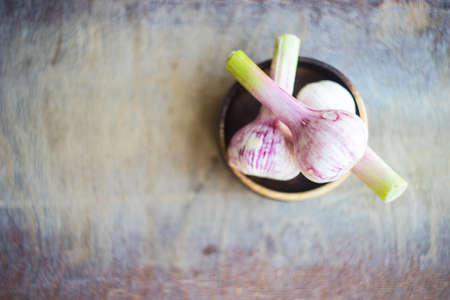 Fresh garlic heads on rustic wooden background with copy spaceの写真素材