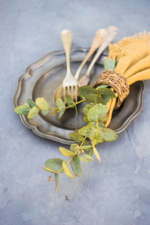 Rustic table setting with vintage silverware and plates on concrete tableの写真素材