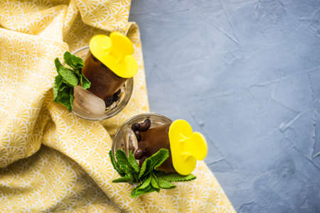 Summer dessert concept coffee lollypops with mint and ice on rustic background with copy spaceの写真素材