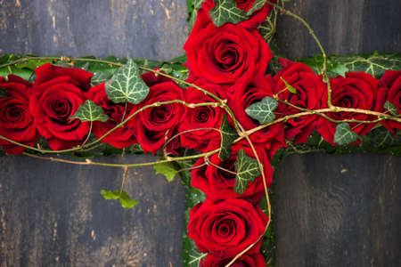 Red roses in floral funerary concept on dark wooden background with copy spaceの写真素材