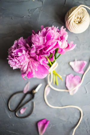 Summer floral concept with bright pink peony flowers on rustic background with copy spaceの写真素材