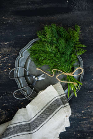 Organic food concept with bunch of dill or fennel on vintage plateの写真素材