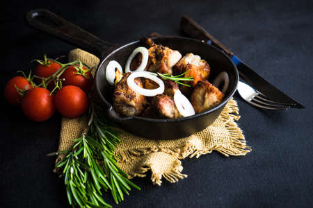 Grilled meat on vintage pan with fresh onion, rosemary and tomato  as a healthy food conceptの写真素材