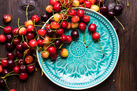 Fresh organic sweet cherries on ceramic bowl with copy space