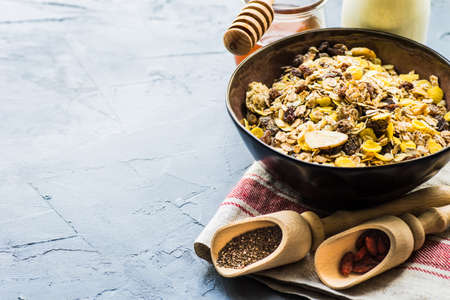 Healthy brekfast concept with  oatmeal, superfood, honey and milk on rustic background with copy...