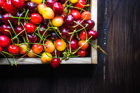 Fresh organic sweet cherries in wooden box with copy space