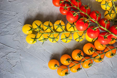 Organic cherry tomato on rustic concrete background with copy spaceの写真素材